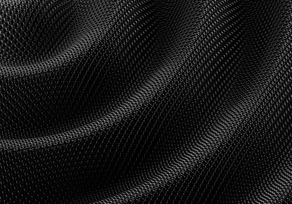 Strukturiertes Muster aus kleinen, ringförmigen Elementen in Schwarz und Grau. Die Oberfläche wirkt gewellt und erzeugt eine plastische Tiefenwirkung.